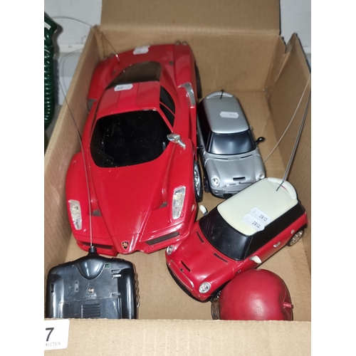 797 - 3 radio controlled cars and two controllers including a red Ferrari and two Mini Coopers. Unchecked