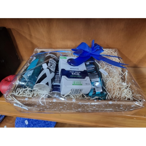 812 - A wrapped gift basket containing mens beauty items.