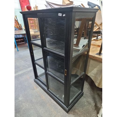 887 - A sleek display cabinet in a dark finish with two shelves and glass sliding doors.H 142cm x W 99cm D... 