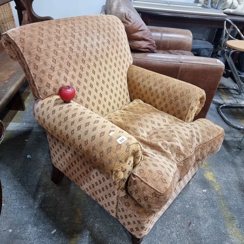 638 - A comfortable armchair with roll back on turned wood legs and brass castors.