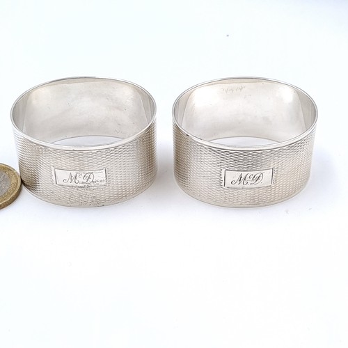 684 - A pair of Sterling Silver napkin rings with machine cut detailing initialled McD, items in original ... 