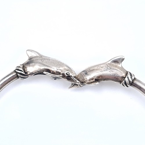 698 - Three sterling silver bangles featuring two gem set examples together with a dolphin dolphin feature... 