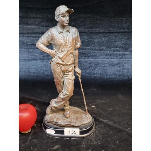 135 - A cast figurine of a golfer in a bronze toned finish.