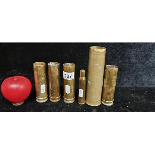 227 - A collection of six vintage early 20th century military brass shell casings, including one from the ... 