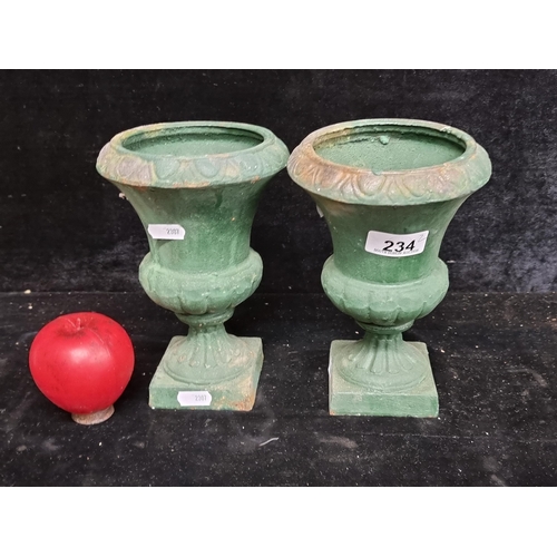 234 - A pair of neatly sized very heavy cast metal garden urns.