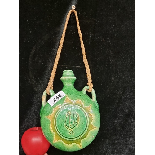 246 - A handmade green glazed ceramic Botija flask. Features a cockerel motif and woven handle.