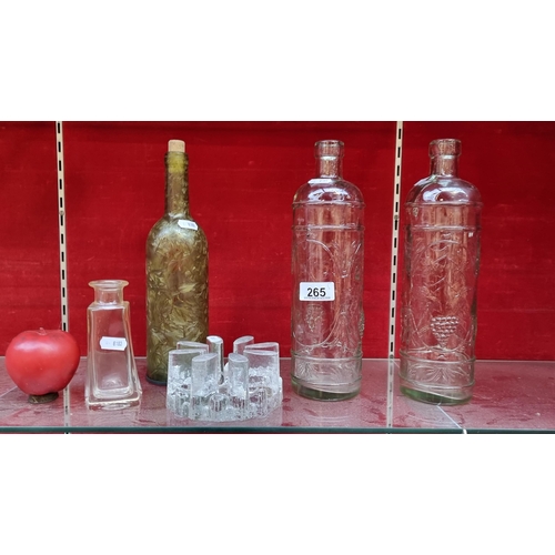 265 - A mixed lot consisting of a crystal plate warmer, two tall glass bottles with grape and vine motif t... 