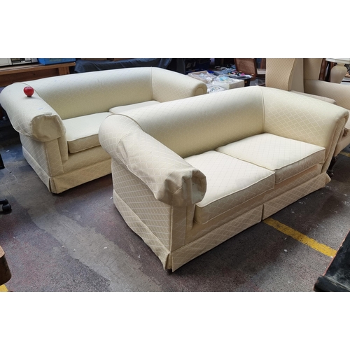 376 - Star Lot: Two fabulous classic two seater roll top sofas on castors. Upholstered in a primrose yello... 