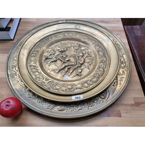 382 - A set of three graduated brass decorative plates featuring lovely hammered / repousse design. Two fe... 