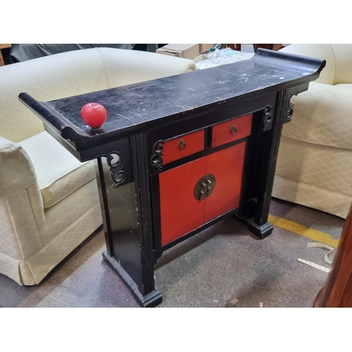 408 - An unusual vintage Chinese wedding table boasting two drawers and cabinet storage to base in a strik... 