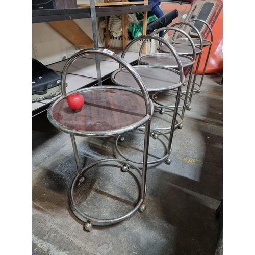 440 - A set of five tubular side tables featuring wooden table top, chrome frames and set on castor wheels... 