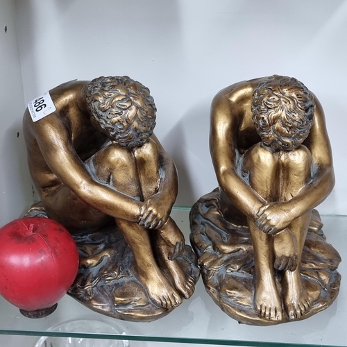 486 - A pair of WJ Sampson & Co. bookends with a bronzed finish showing a seated male.