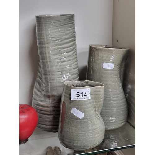 514 - Three unusual graduated art studio pottery jugs in an off grey tone.