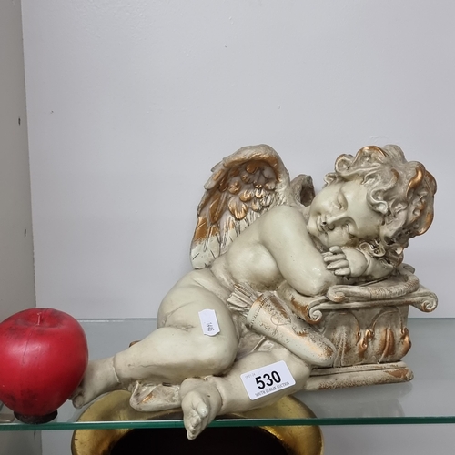 530 - A charming figure of a young resting cherub.