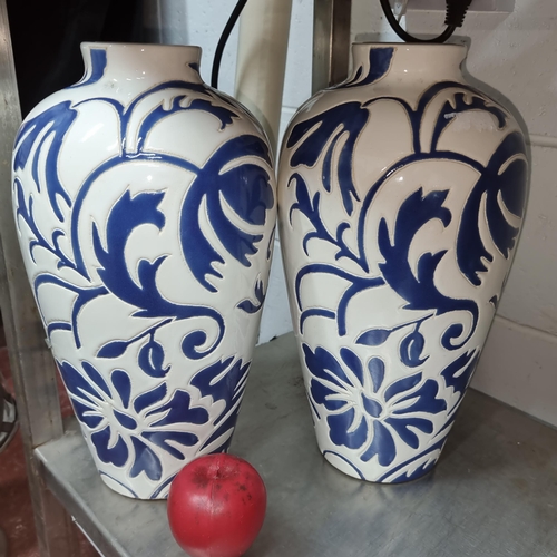 545 - A beautiful pair of large Paul Costelloe Living urn vases boasting a white and blue floral motif. In... 