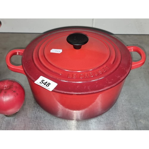 548 - A Le Creuset cast iron dutch oven with lid and handles. In a red finish. In very fresh condition.