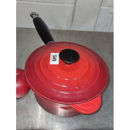 549 - A Le Creuset cast iron 1.8L lidded pot with long handle. In a red finish. Very fresh condition.