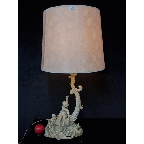 563 - A very ornate table lamp with a heavy base in the form of a rich cornucopia and a cupid. Topped with... 