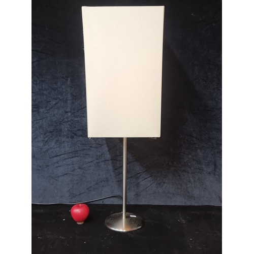 564 - A contemporary table/floor lamp with a sleek chrome base and cream shade.