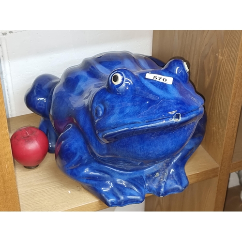 570 - A very large characterful ceramic frog sculpture in a navy glaze finish. Heavy example.