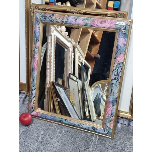 593 - A gilt and rich floral design framed mirror.