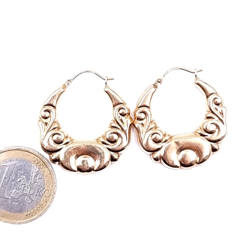 624 - A pair of attractively designed 9K gold hoop earrings, suitable for pierced ears, marked 375 to post... 