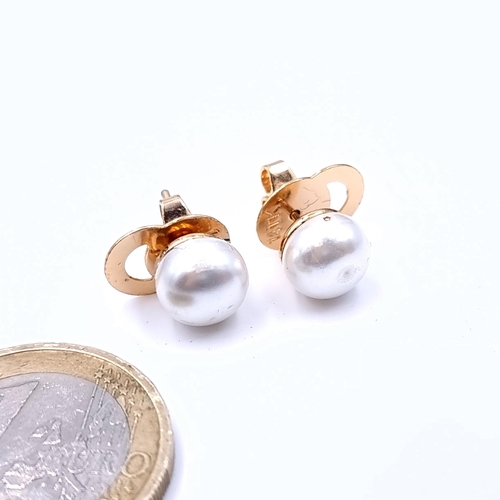 662 - A pair of 9K gold lustre pearl stud earrings.