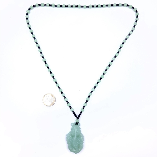 675 - An attractive jade pendant necklace, length 66cm, weight 39.5 grams. Stones cold to the touch