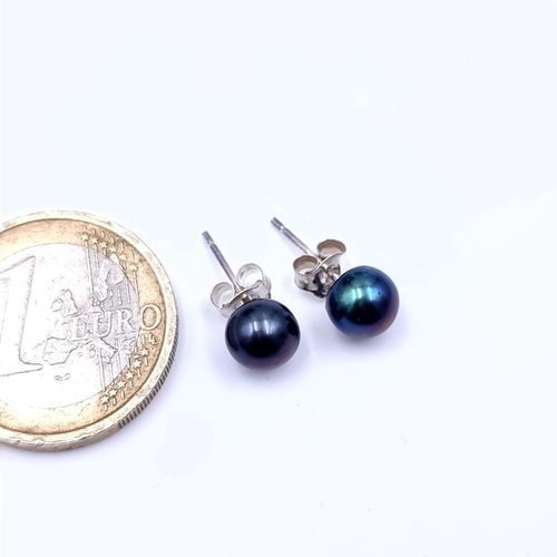 680 - A pair of black lustre pearl stud earrings set in 9K gold, marked to posts, total weight 1.11 grams.