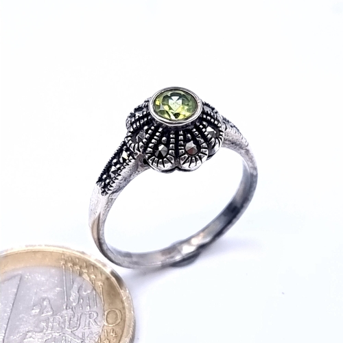 687 - An art deco peridot stone ring set in silver and marcasite detailing, ring size O, weight 3.53 grams... 