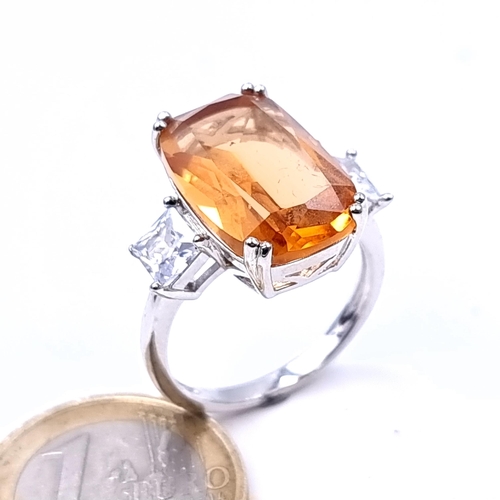 688 - An orange tourmaline stone ring with gem set shoulders set in sterling silver, size T, weight 6.26 g... 