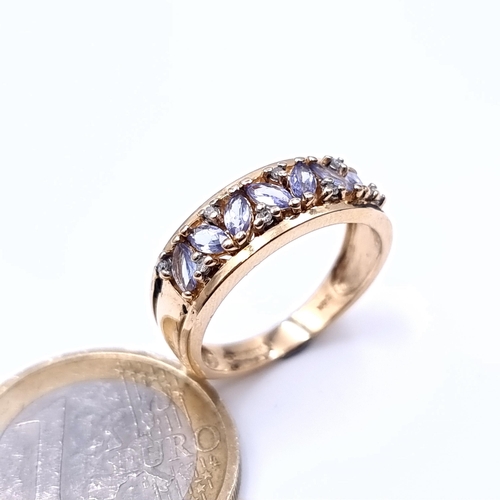 697 - Star Lot : A super 9K gold diamond and tazanite seven stone ring with wide shoulder mount, hallmarke... 