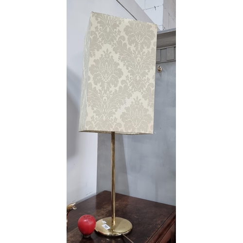 703 - A tall table lamp with a brass base and cream damask shade.