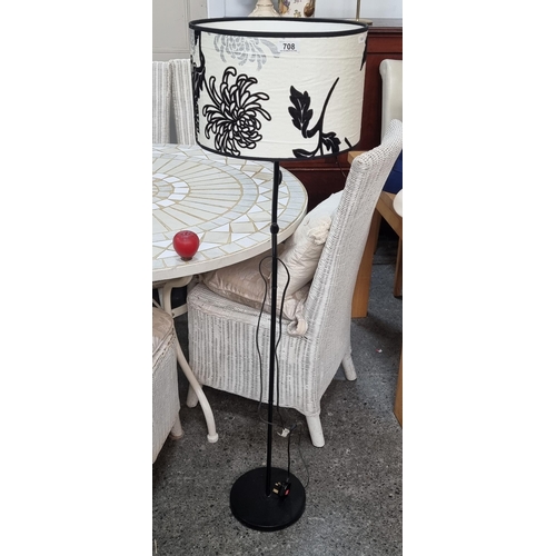 708 - A very chic floor standing lamp with a black metal stem in an organic form, topped with a cream shad... 