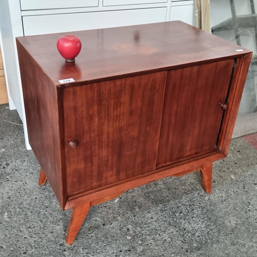 724 - A stylish vintage mid century record cabinet with two sliding doors to front, held on splayed tapere... 