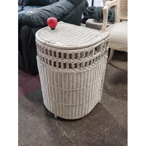 727 - A charming demilune rattan laundry basket in white.