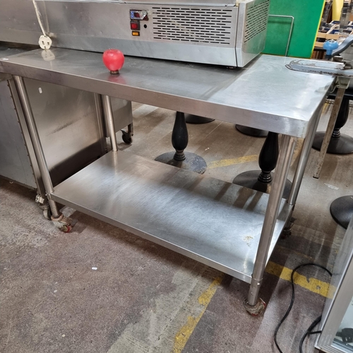 780 - A commercial stainless steel kitchen work station unit with shelf to base, castors and attached can ... 