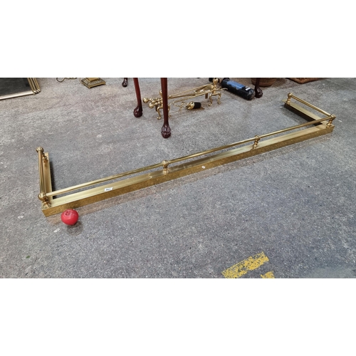 863 - A fabulous and long vintage brass fire fender boasting a surround with round finials. L190cm x W50cm... 