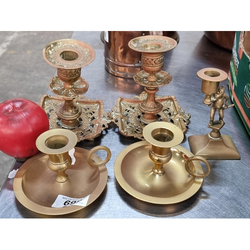 869 - Five elegant brass candle holders including a pair with intricate design.