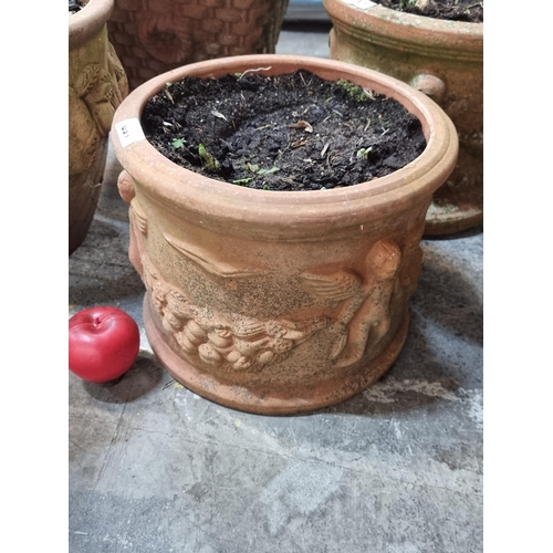 891 - A large heavy circular terracotta planter featuring a wonderful grapevine motif.