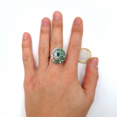 3 - Star Lot : A most attractive oval shaped ring featuring emeralds with diamond and ruby accents set i... 