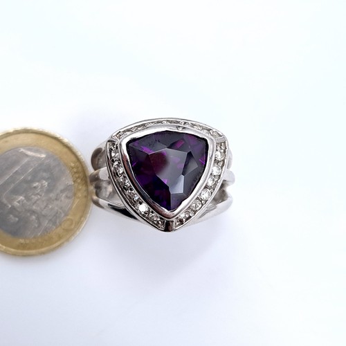 669 - A sterling silver amethyst stone ring with gem set surround, size Q, weight 10.7 grams, boxed.