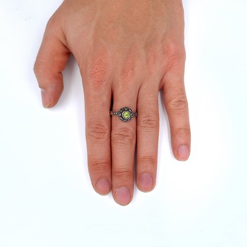 687 - An art deco peridot stone ring set in silver and marcasite detailing, ring size O, weight 3.53 grams... 