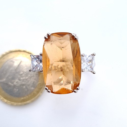 688 - An orange tourmaline stone ring with gem set shoulders set in sterling silver, size T, weight 6.26 g... 