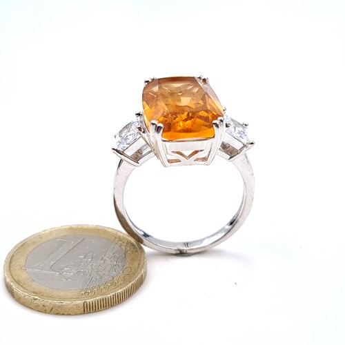 688 - An orange tourmaline stone ring with gem set shoulders set in sterling silver, size T, weight 6.26 g... 