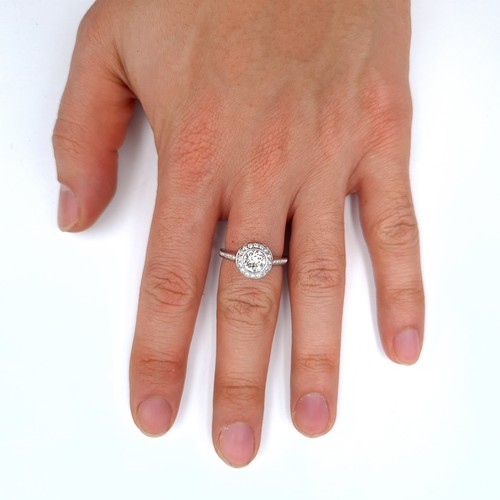 699 - A moissanite stone ring with cluster set Sterling Silver mount, ring size O, weight 3.77 grams.