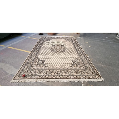 426 - Star lot : A large hand woven Persian style rug boasting an intricate geometric and foliate pattern ... 