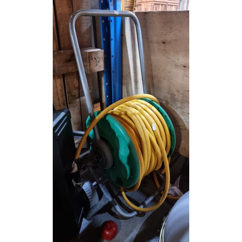 763 - A long garden hose held on a reel with handle.