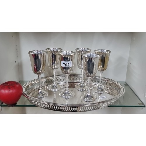 702 - A collection of silver plated goblets along with a pierced engraved silver plated tray.