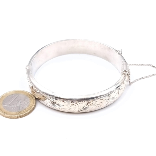 473 - A hallmarked Birmingham sterling silver floral designed bracelet with safety chain, weight 27 grams,... 